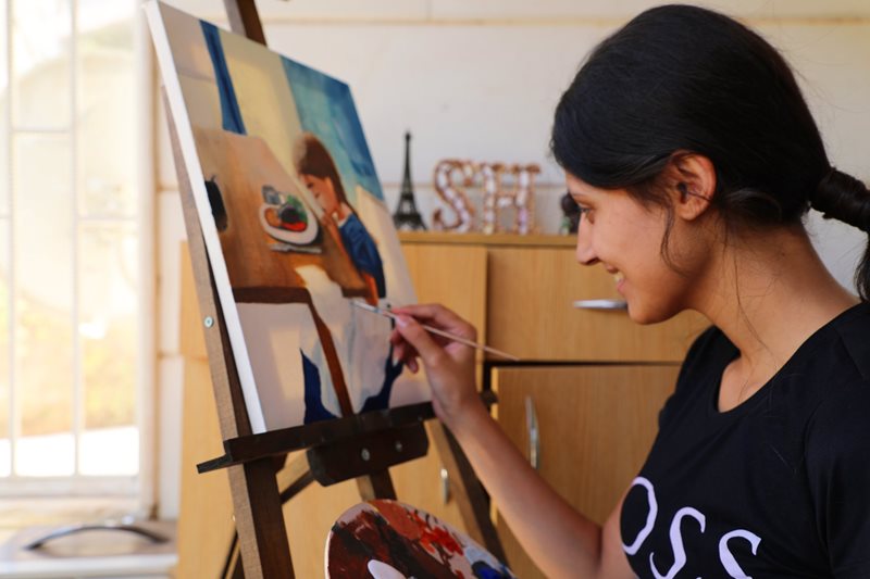 Sabah puts the finishing touches on her painting